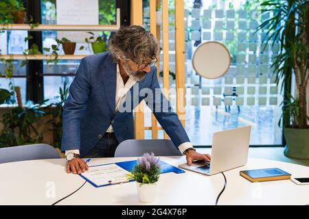 Male entrepreneur working on laptop at office Stock Photo
