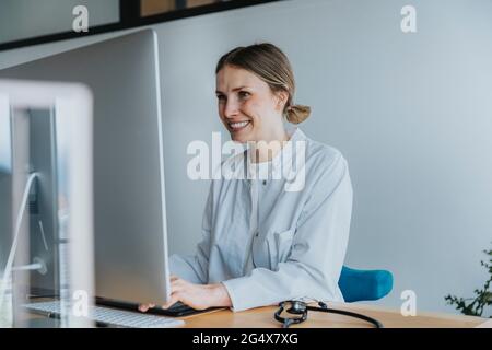 Female healthcare worker using computer at desk Stock Photo