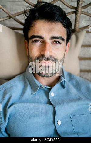 Young man sitting on chair swing in cafe Stock Photo