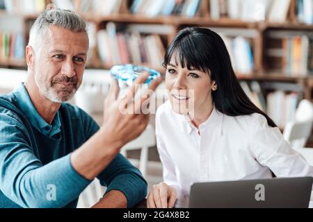Male and female entrepreneurs brainstorming on drone at cafe Stock Photo