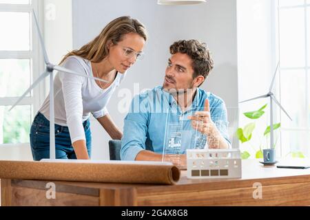 Businessman discussing over digital tablet with colleague in office Stock Photo