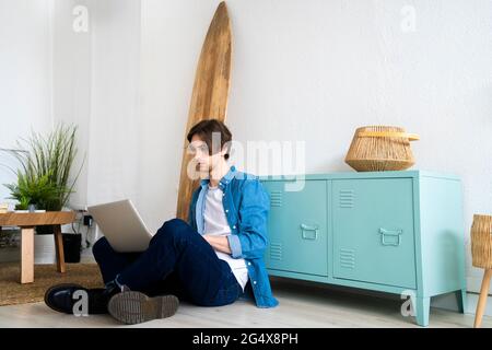 Male entrepreneur using laptop while working at creative workplace Stock Photo