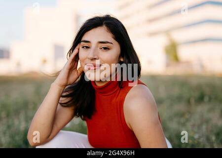 Young woman wearing sleeveless top staring while smiling Stock Photo
