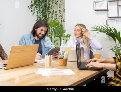 Male and female professionals working together in creative office Stock Photo