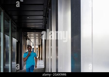 Young man running in corridor Stock Photo