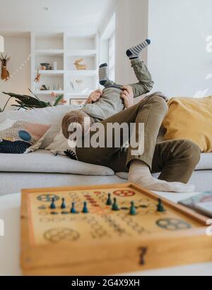 Father playing with son while sitting on sofa at home Stock Photo