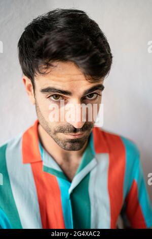 Young man in striped multi colored shirt Stock Photo