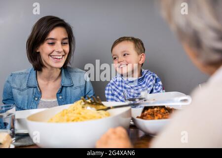 Multi-generation family smiling while having food at home Stock Photo