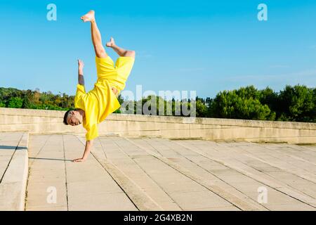Young man doing handstand while dancing on steps Stock Photo