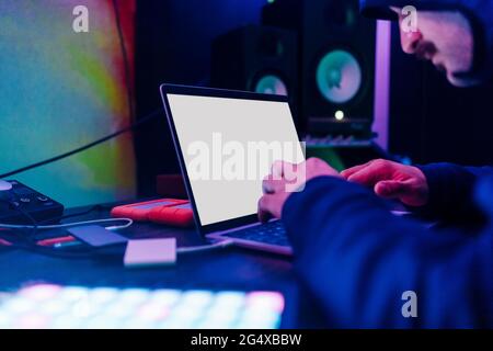Male hacker analyzing data on laptop at home Stock Photo