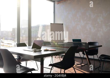 Empty chairs and laptop at tennis table in office Stock Photo
