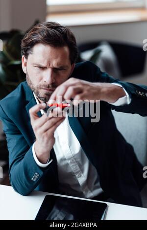 Businessman checking drone while siting at office Stock Photo