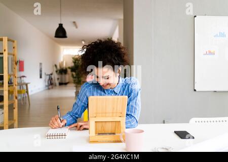 Businesswoman smiling while working in creative office Stock Photo