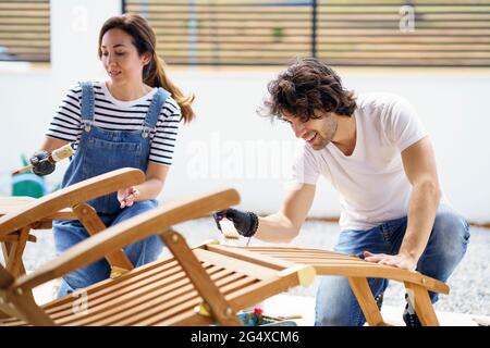 Couple polishing lounge chair together Stock Photo