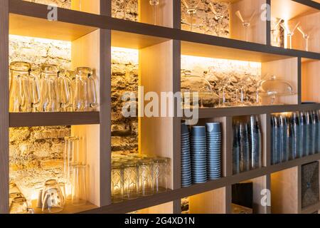 Glasses arranged on shelf in bar Stock Photo