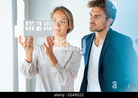 Mid adult architects brainstorming over architectural model in office Stock Photo