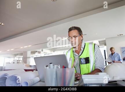 Concentrated male architect working on laptop in office Stock Photo