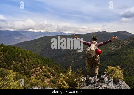 Mid adult tourist standing with arms outstretched on mountain Stock Photo