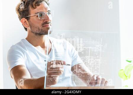 Male entrepreneur using futuristic digital tablet in office Stock Photo
