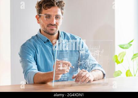 Male architect using futuristic digital tablet while working in office Stock Photo