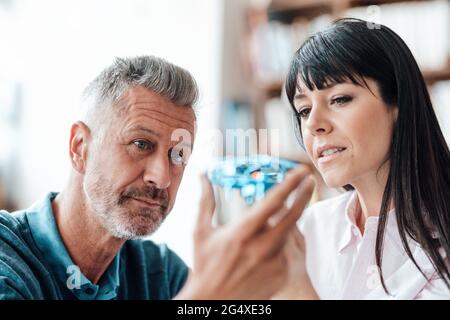 Colleagues checking drone while working at cafe Stock Photo