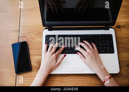 Female freelance worker using laptop at cafe Stock Photo