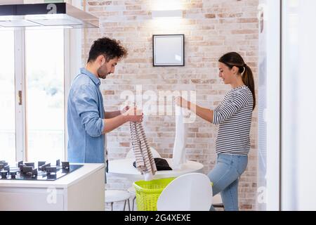 Couple folding clothes together in the kitchen at home Stock Photo