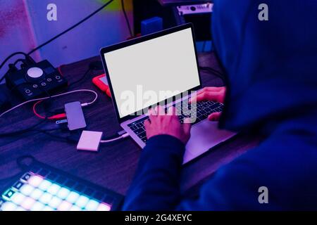 Male data hacker using laptop at home Stock Photo