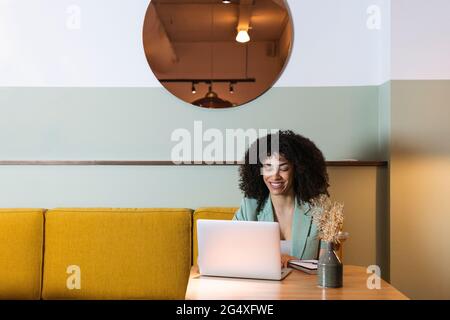 Female freelance worker using laptop in restaurant Stock Photo