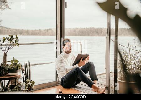Male freelance worker using digital tablet at houseboat Stock Photo