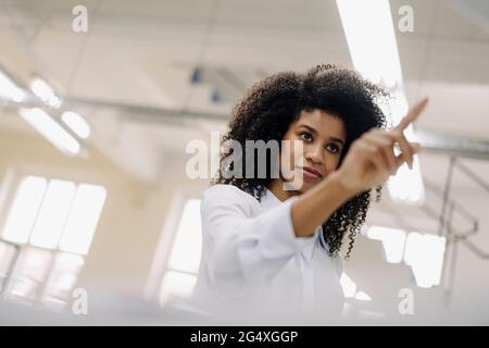 Businesswoman touching product in industry Stock Photo