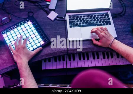 Man using digital tablet and laptop while composing music at studio Stock Photo