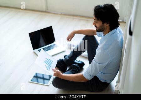 Businessman with digital tablet and laptop analyzing graph document in office Stock Photo