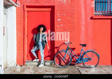 Young afro hair woman smiling while standing at entrance Stock Photo