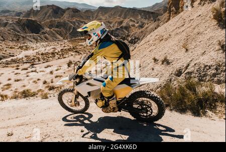 Sportsperson in protective sportswear riding enduro motorcycle on dirt road Stock Photo