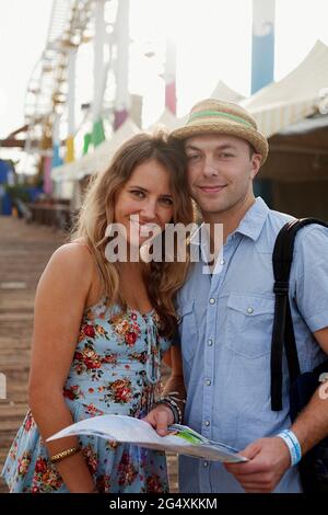 Smiling woman with man wearing hat at Santa Monica Stock Photo
