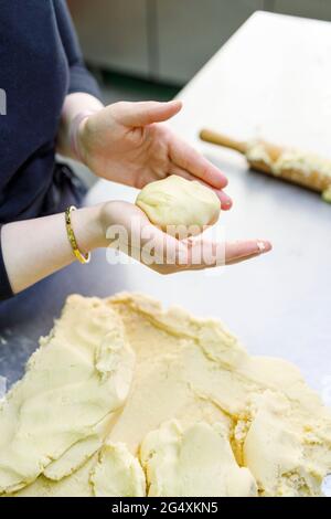 Female baker with dough working in bakery Stock Photo