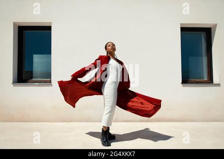 Woman in red overcoat holding a Mulberry Roxanne leather handbag