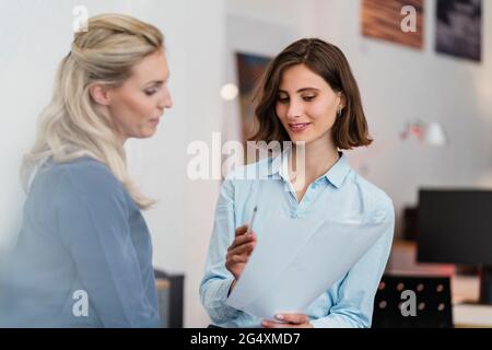 Female entrepreneurs discussing over document in office Stock Photo