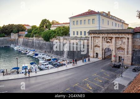 Croatia, Zadar County, Zadar, Parking lot in front of 16th century Land Gate with boats moored in background Stock Photo