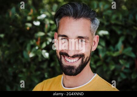 Smiling bearded man in front of plants Stock Photo