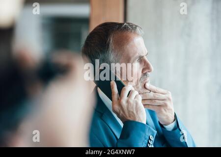 Senior businessman talking on mobile phone in office Stock Photo