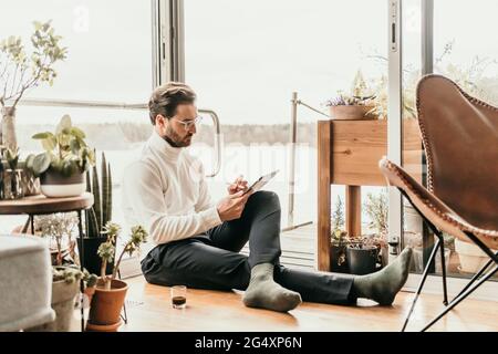 Male freelance worker using digital tablet at houseboat Stock Photo