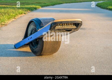 One wheeled electric skateboard personal transporter on a lake