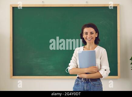 Teacher at the blackboard teaches students in the classroom in college Stock Photo