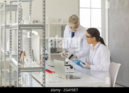 Scientists working in laboratory, taking test samples and doing medical research Stock Photo