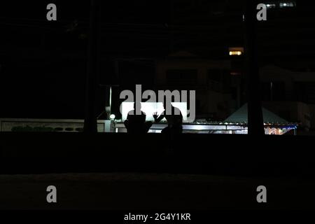 A dialogue of two men, visible only as silhouettes, with one hearing intrigued and another one gesturing Stock Photo