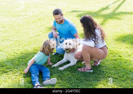 happy family of mother father and son playing with dog in park on green grass, family Stock Photo