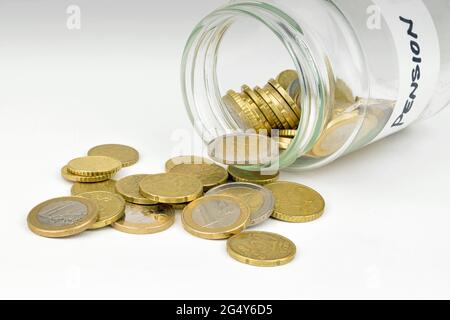 A jam jar full of Pound Euro coins spilling out of a pension savings jar. Stock Photo