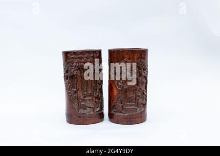 two vintage bamboo carved wooden brush holder pots on a white studio background Stock Photo